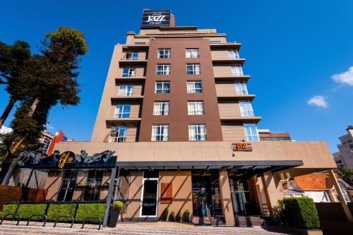 a tall building with a sign on top of it at FULL JAZZ by Slaviero Hotéis in Curitiba