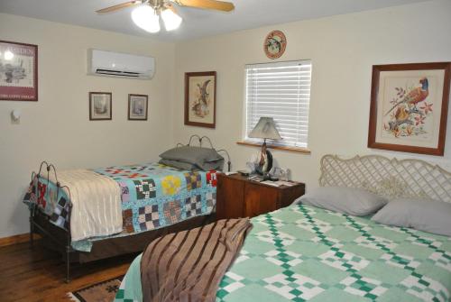 Vernon的住宿－Rustic Red River Retreat，一间卧室配有两张床和吊扇
