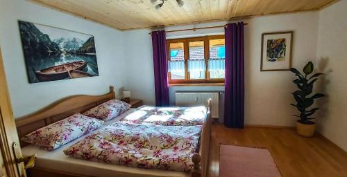 um quarto com uma cama e uma janela em Ferienwohnung Reisenauer em Marquartstein