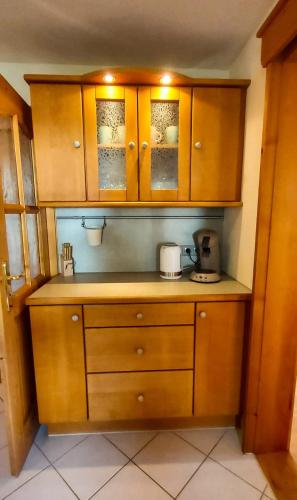 a kitchen with wooden cabinets and a coffee maker at Ferienwohnung Reisenauer in Marquartstein