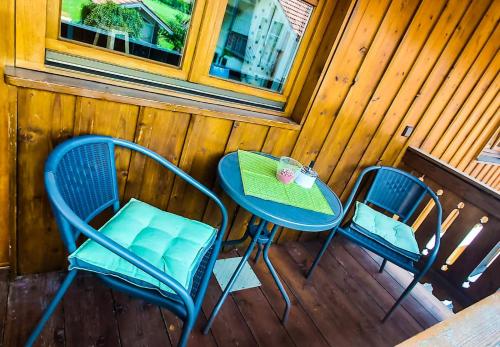 two chairs and a table on a porch at Ferienwohnung Reisenauer in Marquartstein