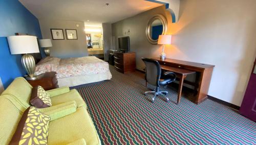 a hotel room with a bedroom with a desk and a bed at Magnuson Hotel Marietta in Marietta