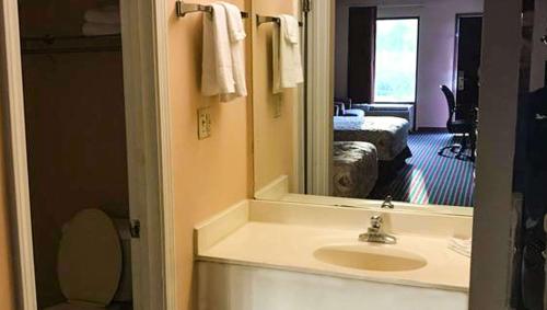 a bathroom with a sink and a mirror at Magnuson Hotel Marietta in Marietta