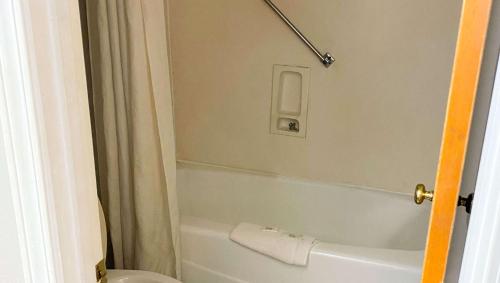 a bathroom with a white tub and a toilet at Magnuson Hotel Marietta in Marietta