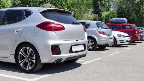 a row of parked cars in a parking lot at Magnuson Hotel Marietta in Marietta