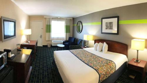 a hotel room with a bed and a living room at Magnuson Hotel Virginia Beach in Virginia Beach
