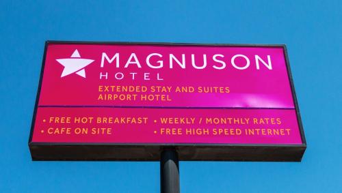 a pink sign for a macaroon hotel at Magnuson Extended Stay and Suites Airport Hotel in Irving