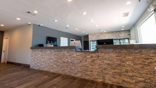 a lobby with a stone counter and a brick wall at Magnuson Extended Stay and Suites Airport Hotel in Irving