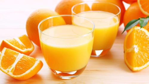 two glasses of orange juice and oranges on a table at Magnuson Extended Stay and Suites Airport Hotel in Irving