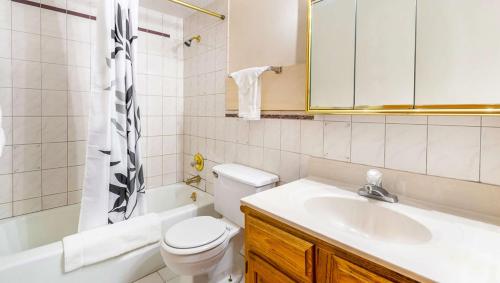 ein weißes Bad mit einem Waschbecken und einem WC in der Unterkunft Magnuson Hotel Extended Stay Canton Ohio in Lake Cable