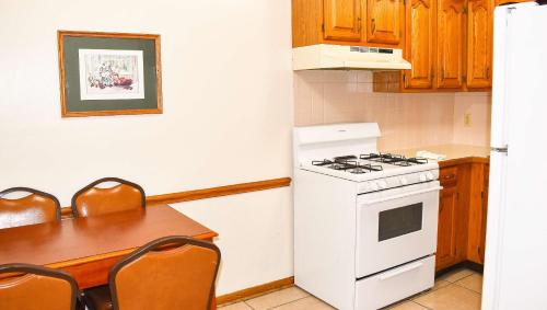 a kitchen with a stove and a table with chairs at Magnuson Hotel Extended Stay Canton Ohio in Lake Cable