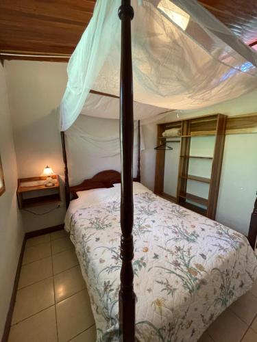 a bedroom with a four poster bed with a canopy at Finca Isla Rainforest Retreat in Aguas Zarcas