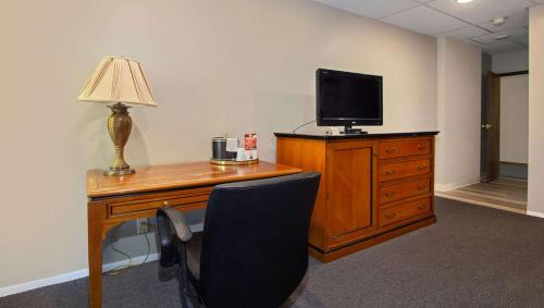 a room with a desk with a television and a chair at M Star North Canton - Hall of Fame in North Canton
