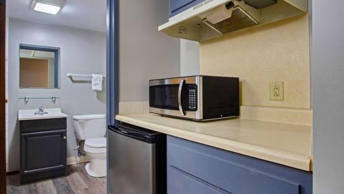 a kitchen with a microwave on top of a counter at M Star North Canton - Hall of Fame in North Canton
