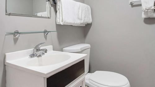 a white bathroom with a sink and a toilet at M Star North Canton - Hall of Fame in North Canton