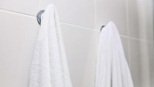 a white towel hanging on a wall in a bathroom at M Star North Canton - Hall of Fame in North Canton