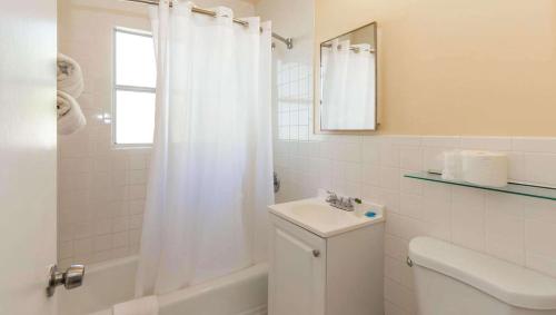 a bathroom with a toilet and a sink and a shower at Belleair Beach Resort Motel in Clearwater Beach