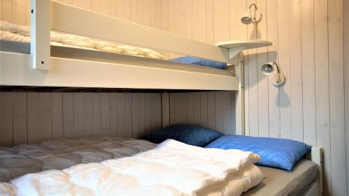a small room with a bed and some shelves at Beverøya Hytteutleie og Camping in Bø