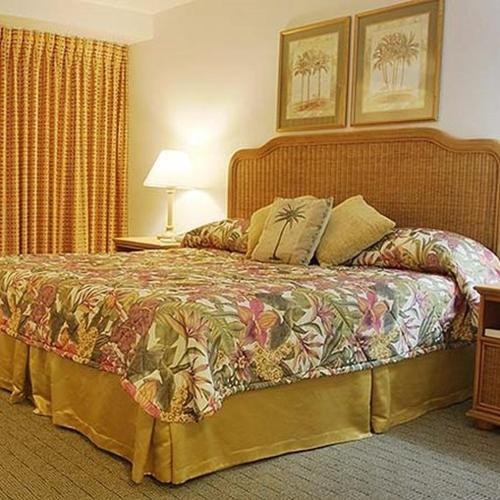 a bedroom with a bed with a colorful bedspread at Castaways Resort and Suites in Freeport