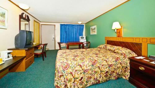 een hotelkamer met een bed en een flatscreen-tv bij M Star Hotel Covington in Covington