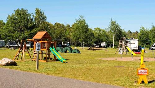 a park with a playground with a slide and swings at Jasper Ridge Inn Ishpeming in Ishpeming