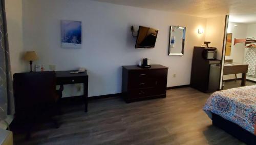 a bedroom with a bed and a dresser and a mirror at Jasper Ridge Inn Ishpeming in Ishpeming