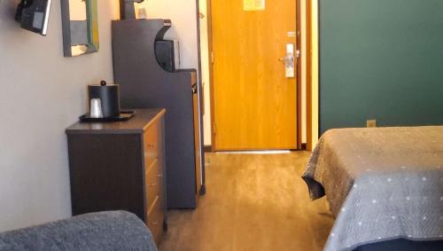 a bedroom with a bed and a dresser and a door at Jasper Ridge Inn Ishpeming in Ishpeming