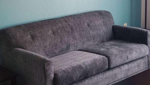 a gray couch sitting in a room next to a wall at Jasper Ridge Inn Ishpeming in Ishpeming