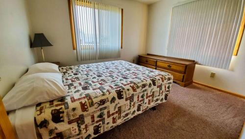 a bedroom with a bed and a dresser and window at Jasper Ridge Inn Ishpeming in Ishpeming