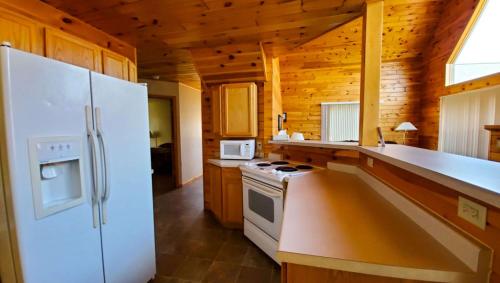 a kitchen with a white refrigerator and a stove at Jasper Ridge Inn Ishpeming in Ishpeming