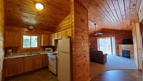 a kitchen with a white refrigerator in a wooden cabin at Jasper Ridge Inn Ishpeming in Ishpeming