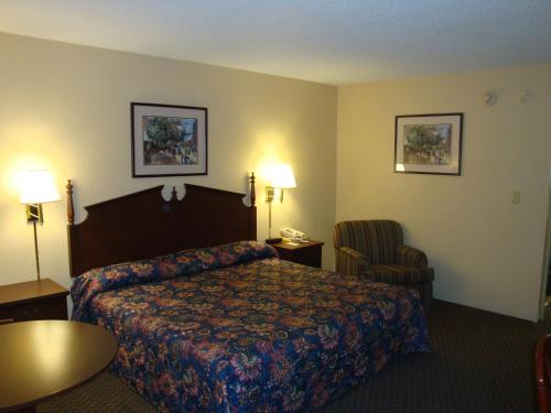 um quarto de hotel com uma cama e uma cadeira em Wilmington Inn em Wilmington