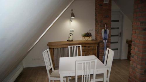 a dining room with a white table and chairs at Lawendowe Siedlisko in Suwałki