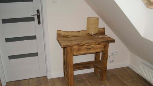 a wooden table with a basket on top of it next to a staircase at Lawendowe Siedlisko in Suwałki
