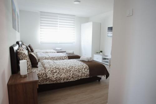 a bedroom with two beds and a window at APARTMANI CENTAR LUX NEW in Zrenjanin