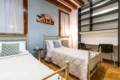 a room with two beds and a table and chairs at San Marco - 2 bedrooms with lift in Venice