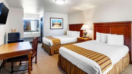 En eller flere senger på et rom på Magnuson Grand Hotel and Conference Center Tyler