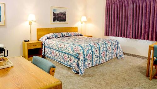 Ruby Inn Bridgeport في بريدجبورت: غرفه فندقيه بسرير وطاولة وكرسي