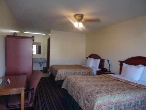 Huggy Bear Motel - Warren في Warren: غرفة فندقية بسريرين ومكتب