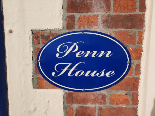 a blue sign that says pen house on a brick wall at Penn House Hotel in Weymouth
