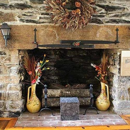 two vases sitting in front of a stone fireplace at Hometown Inn Staunton in Greenville