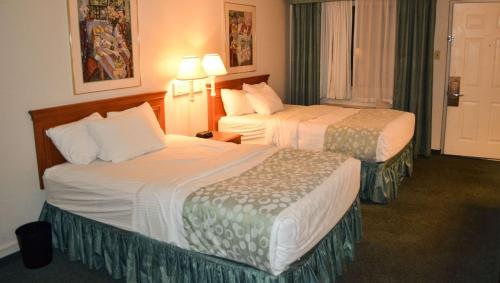 a hotel room with two beds and a window at Magnuson Hotel Texarkana in Texarkana