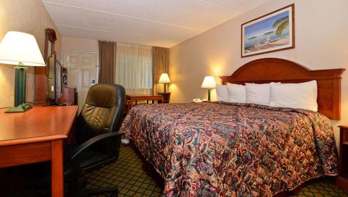 Habitación de hotel con cama y escritorio en Stratford Motor Inn East Ellijay en East Ellijay