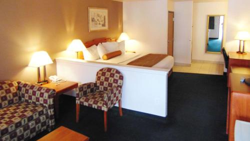 a hotel room with a bed and a chair at Magnuson Hotel Manitou Springs in Manitou Springs