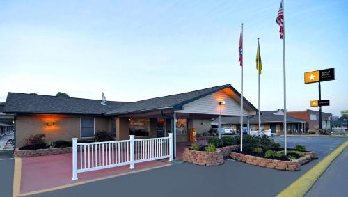 un restaurante con banderas frente a una calle en M Star Hotel Searcy, en Searcy