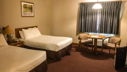a hotel room with two beds and a table at Adirondack Lodge Old Forge in Old Forge