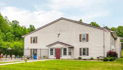 a large white barn with a red door at Royal Inn Rockville in Rockville