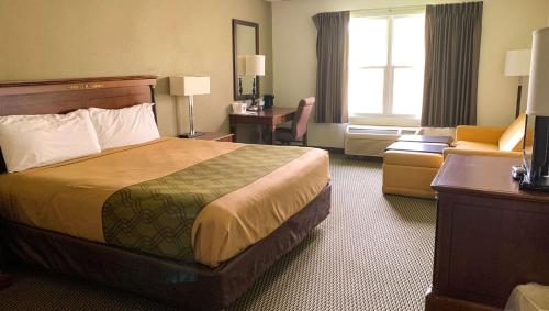 a hotel room with a bed and a chair at Royal Inn Rockville in Rockville
