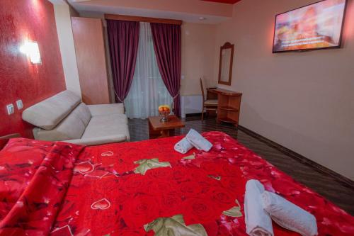 a hotel room with a red bed with roses on it at Villa Dislievski in Ohrid