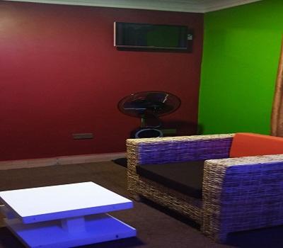 a room with two chairs and a green wall at Bethel Resort & Hotels in Gulu